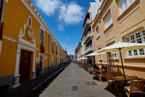 Bustling old town street with cafés and yellow buildings, UNESCO World Heritage Old Town of San