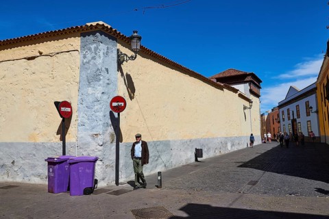 Street scene with man, signs and historic buildings under clear sky, UNESCO World Heritage Old Town