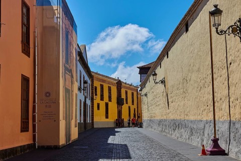 Painted street scene with historic buildings under blue sky, UNESCO World Heritage Old Town of San