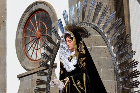 Good Friday procession, statue of Saint Mary in magnificent clothing against a church background,