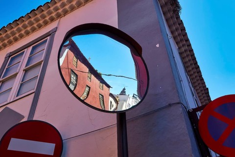 Distorted reflection of houses and road signs in a convex mirror, UNESCO World Heritage Old Town of