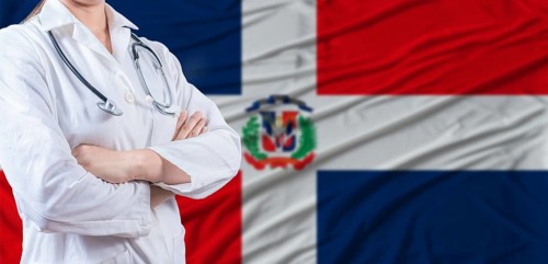 Doctor with crossed arms on Dominican Republic flag. Dominican health and care concept. Female