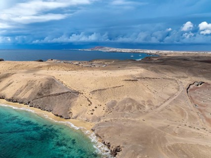 Coast with Playa Caleta del Congrio beach and blue sea, arid landscape of Los Ajaches Natural Park,