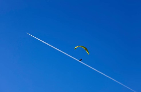 Paragliders with contrails in the blue sky, Osterhorn Group, Salzkammergut, Province of Salzburg,