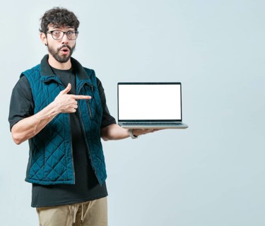 Portrait of bearded handsome man showing laptop screen isolated. Surprised Handsome Man with