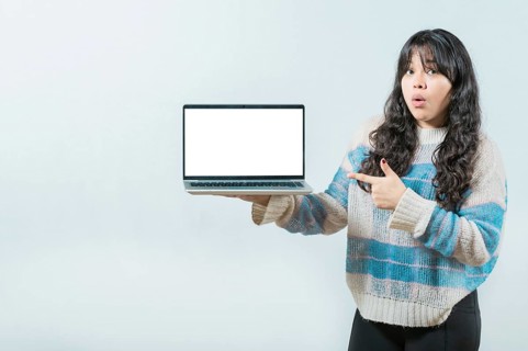 Surprised Young Asian woman displaying a promotion on laptop screen. Portrait of beautiful asian