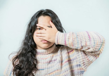 Close up of woman with conjunctivitis isolated. Female with eye infection looking at camera