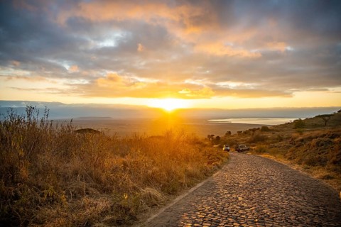 Road leading into Ngorongoro Crater, at sunrise, atmospheric morning light, view of Ngorongoro