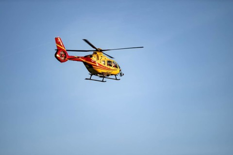 Rescue helicopter flying against a blue sky, Tyrol, Austria
