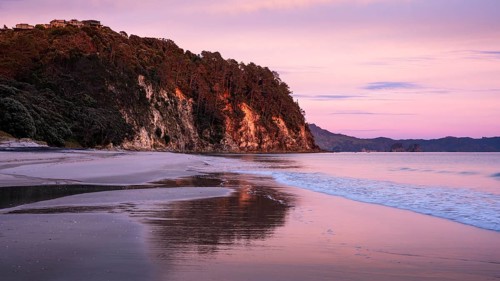 Landscape with sea and sandy beach in New Zealand. Hahei Beach at sunrise in the morning. Hahei,