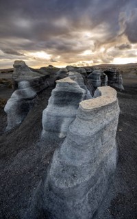 Eroded rock formations, volcanic landscape with dramatic cloudy sky at sunset, Ciudad Estratificada