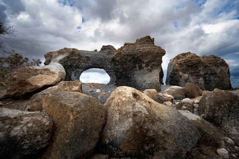 Eroded rock formations with rock tunnels, volcanic landscape with dramatic cloudy skies, Ciudad