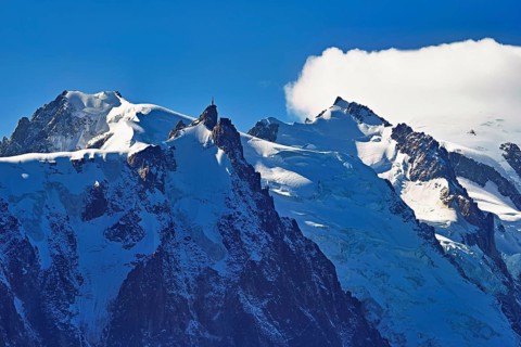 From left snow-covered Mont Blanc du Tacul, Aiguille du Midi, Mont-Blanc in the clouds,