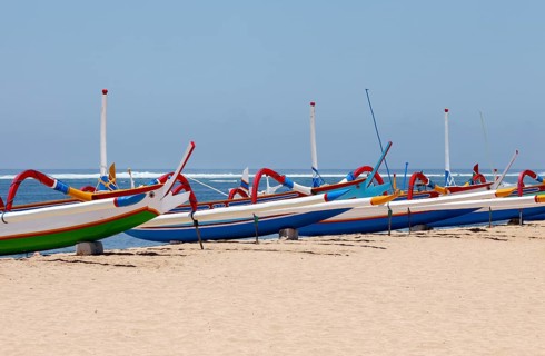Colourfully painted outrigger fishing boats, (Junkung), on Sanur beach, Bali, Indonesia