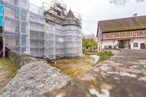 Scaffolded building, adjacent to a half-timbered house in a historic village, Wasserschloss Glatt,
