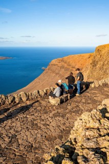 Tourists sitting on a bench on the observation deck at the Mirador del RÃ­o viewpoint, in the
