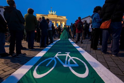 Athena Macke (costume designer) wears a dress with a long train in the shape of a bike path (bike