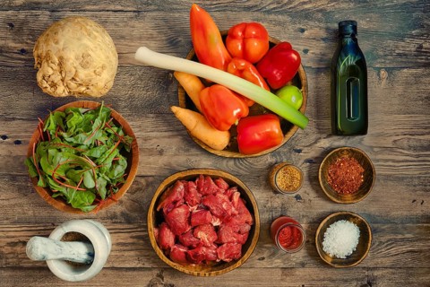 A vibrant assortment of fresh ingredients arranged on a wooden tabletop, illustrating healthy