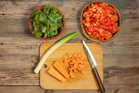 Preparation of fresh vegetables on a wooden cutting board for a healthy salad