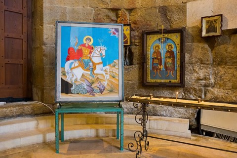 Two icons on a metal stand in a traditional church room with stone walls, Bagrati Cathedral, Church
