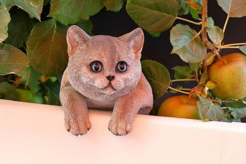 Ceramic cat looking intently in a garden, Wilnsdorf, North Rhine-Westphalia, Germany