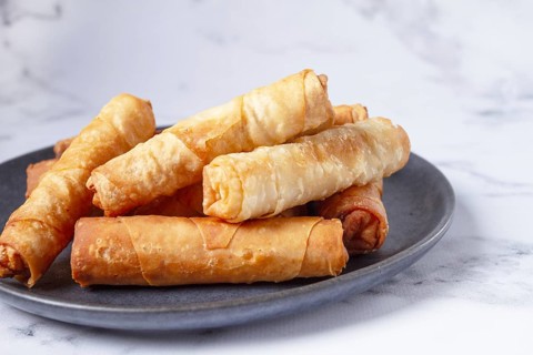 Fried spring rolls with cheese, on a plate, with cream sauce, no people