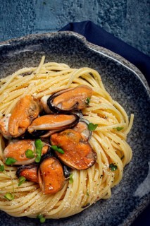 Spaghetti with mussels, without shell, pasta with peeled mussels, in carbonara sauce, micro-greens,