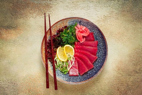 Tuna sashimi with daikon and wakame salad, pickled ginger, in a bowl