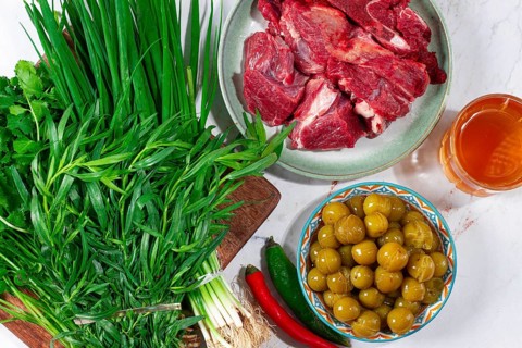 Ingredients for cooking chakapuli, canned tkemali, meat, herbs Georgian cuisine, top view