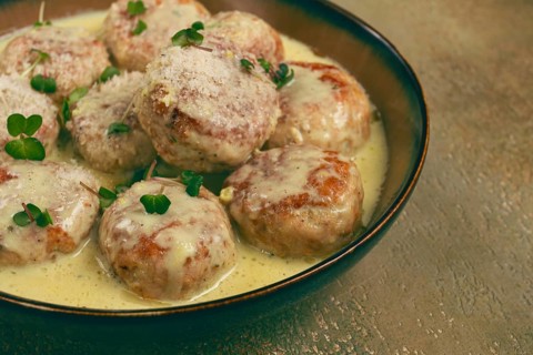 Chicken meatballs, in cream sauce, garnished with parmesan cheese, and microgreens, homemade, no