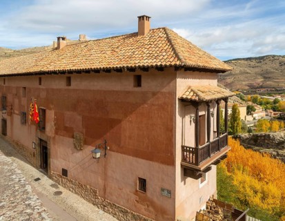 Alberque hostel building with flags flying, historic buildings in medieval village of AlbarracÃ­n,