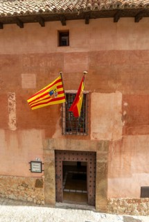 Alberque hostel building with flags flying, historic buildings in medieval village of AlbarracÃ­n,
