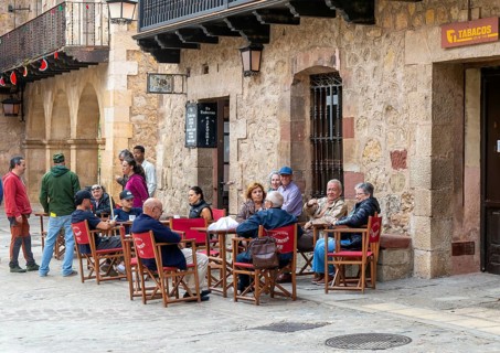 People sitting outside La Taberna bar cafe restaurant, Plaza Mayor, medieval village of