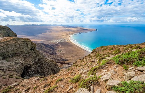 View from the Risco de Famara cliffs to the coast and the sea with the Famara beach, Playa de