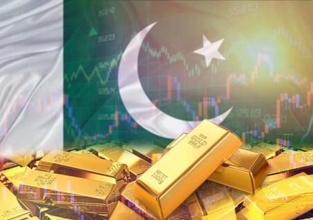 Gold bars on Pakistan flag in background. Gold bars stacked on Pakistani flag. Concept of Pakistan