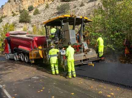 Asphalt road construction team of workers resurfacing tarmac in rural area, near Albarracin, Teruel