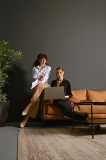 Two women focus on their work as they share ideas and discuss projects while seated in an office