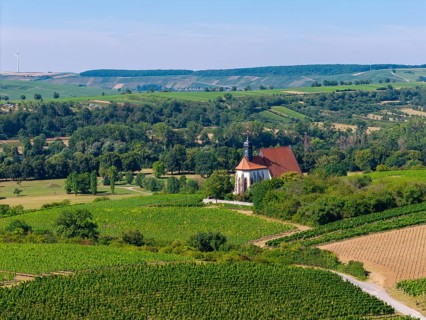 Pilgrimage church Maria im Weingarten, embedded in a green, rural landscape with blue sky, aerial