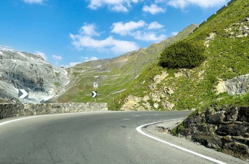 View of the hairpin bend in front with signpost 16th hairpin bend Tornante 2320 metres narrow,