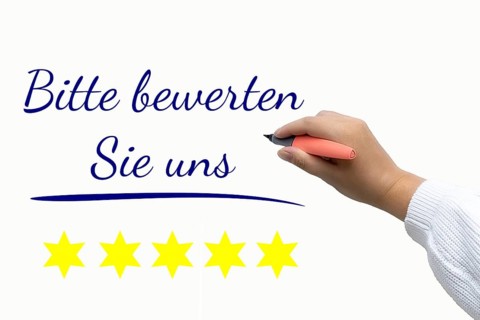 Rating Symbol image: Text PLEASE RATE US next to cropped arm of a woman with writing instrument in