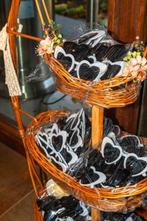 Heart shaped sunglasses are displayed in wicker baskets, adding a playful touch to wedding