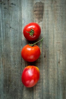Freshly picked ripe tomatoes showcasing vibrant colors and textures on rustic wooden surface