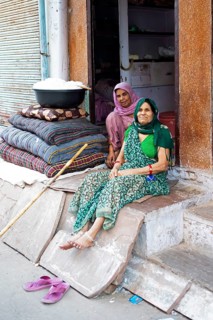 Indian tailors sit next to a tub of cotton in the old city centre, Bundi, Rajasthan, India