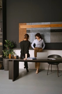Two women discussing work in a modern office space with elegant decor and stylish furnishings