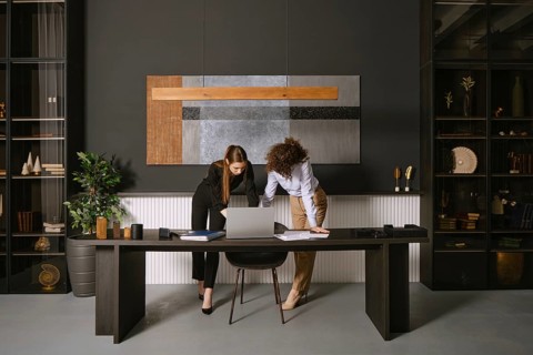 Two business professionals are engaged in a collaborative discussion around a laptop at a sleek