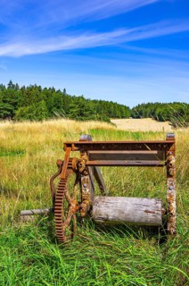 Traditional historical and rusty weathered agricultural equipment in a rural setting near
