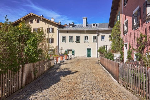 Old town, historic houses, street, cobblestones, facade, windows, doors, bushes, blue sky,