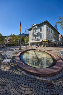 Wisbacherbrunnen, fountain, public chairs, flagpoles, flags, German flag, Bavarian flag, pedestrian