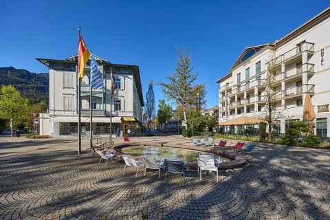 Wisbacherbrunnen, fountain, public chairs, flagpoles, flags, German flag, Bavarian flag, building,