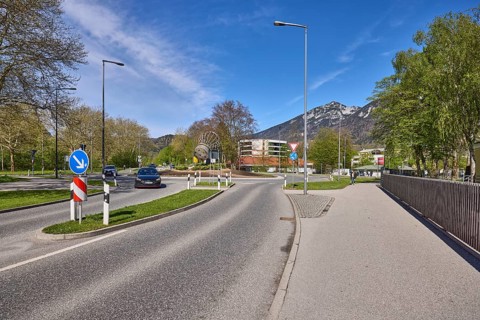 Road, traffic island, roundabout, lantern, metal railing, trees, lawn, mountain landscape,